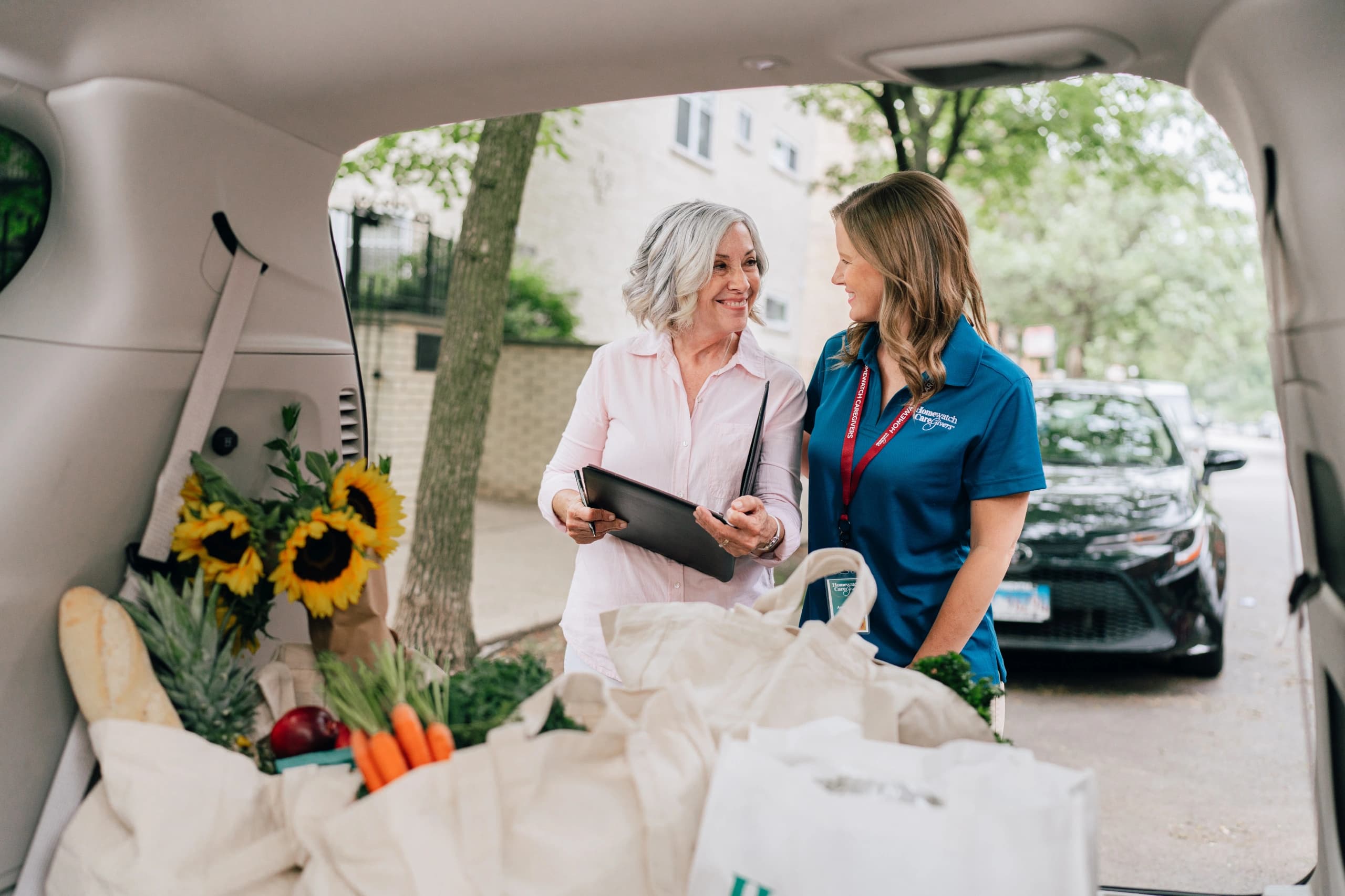 HWCG caregiver helping a client unload groceries